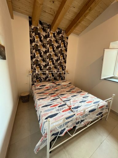 Helles Schlafzimmer mit einem Bett, gestreifter Bettwäsche und einer gemusterten Wand.