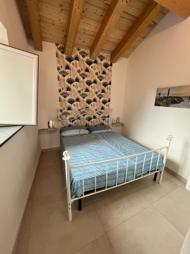 Zimmer mit einem Doppelbett, Holzbalkendecke und schickem Wanddesign.