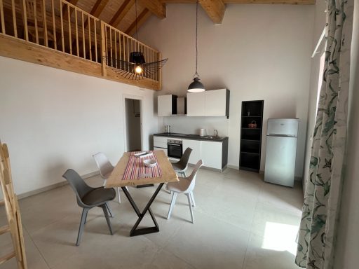 Helle, moderne Küche mit Esstisch und Stühlen in einem Holzhaus.
