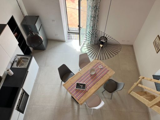 Moderne Küche mit Essbereich, Holztisch und stilvollen Stühlen in einem hellen Raum.