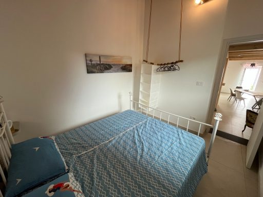 Helles Schlafzimmer mit einem Bett und einem Bild an der Wand.